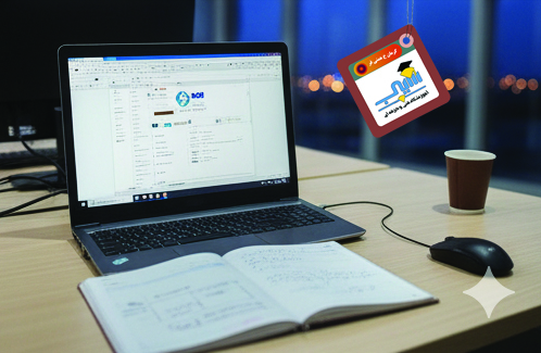 نمای نزدیک از یک برد اعلانات قهوه‌ای با اطلاعات مربوط به دوره ICDL به زبان فارسی و همچنین یک لپ‌تاپ باز شده که وب‌سایت یا محتوای آموزشی آموزشگاه سیب را نمایش می‌دهد.